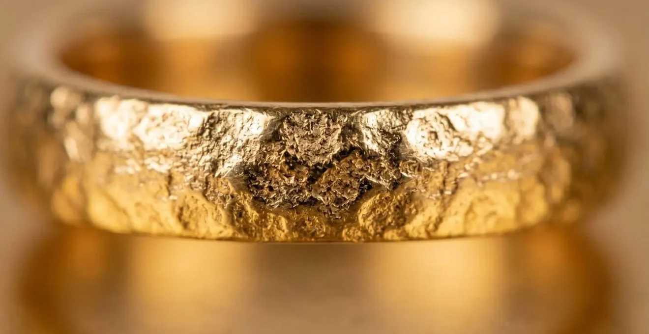 Detalle macro de superficie de joya bañada en oro mostrando acabado brillante