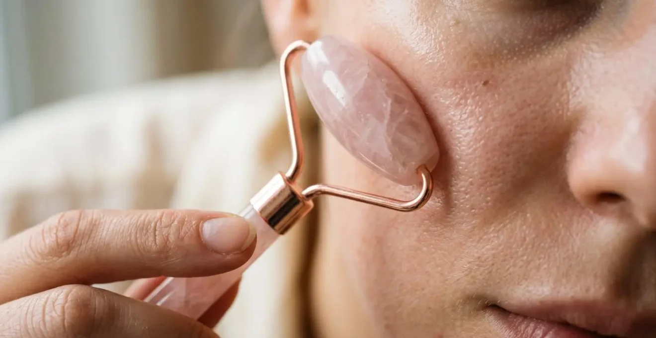 Primer plano de tecnica de masaje facial con rodillo de cuarzo rosa mostrando movimiento ascendente