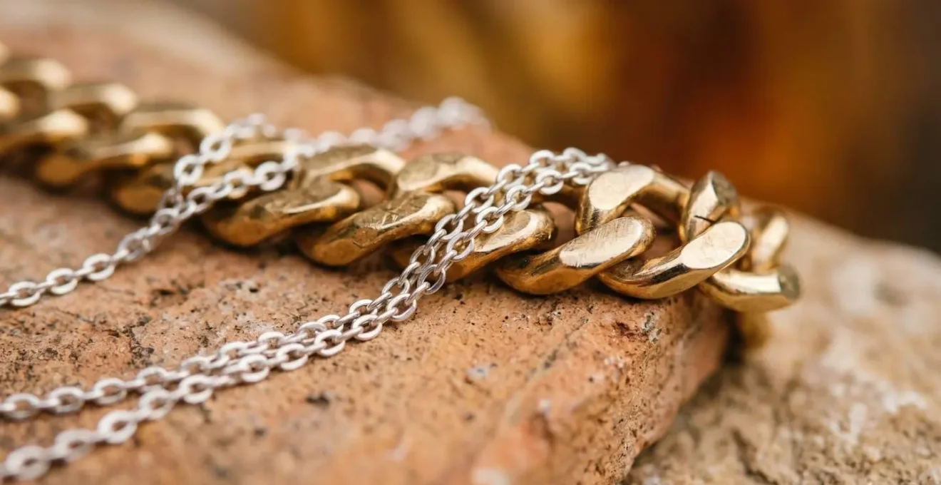 Detalle macro de bisutería combinando metales dorados y plateados con texturas naturales que reflejan el street style contemporáneo español
