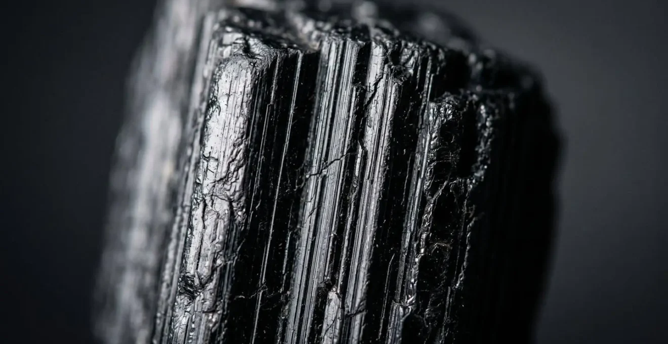 Detalle macro de estrías naturales en turmalina negra auténtica con iluminación lateral